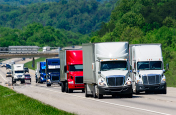 Plusieurs camions commerciaux roulant sur une autoroute