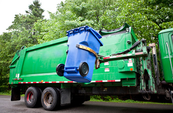 Camion benne chargeant bac de matières recyclables